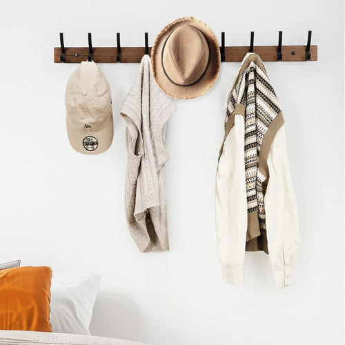 Wood and black metal coat rack styled in bedroom with hats and vests