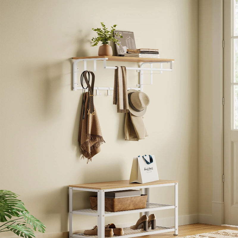 Porte manteau mural étagère en bois claire et structure en métal blanc avec crochets et barre pour rangements supplémentaires installé dans une entrés bien rangée et lumieuse 