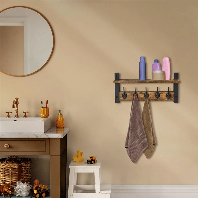 Porte manteau étagère murale flottante avec crochets en métal instalé dans une salle de bain familiale