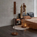 Pair of dark wood coat racks with stainless steel columns in modern bedroom