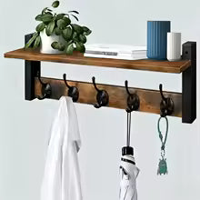 Warm tone wooden coat rack with matte black hooks holding white garment on gray wall