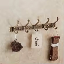 Silver multi-hook wall rack holding loofah and woven mat